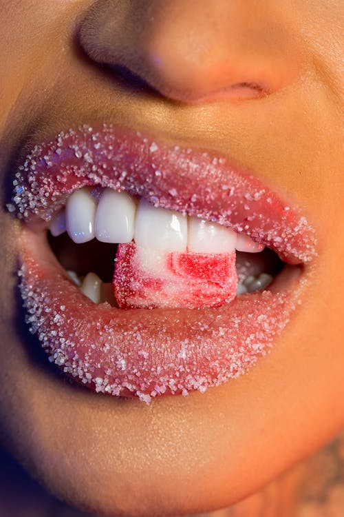 photo of a mouth biting a sugary candy