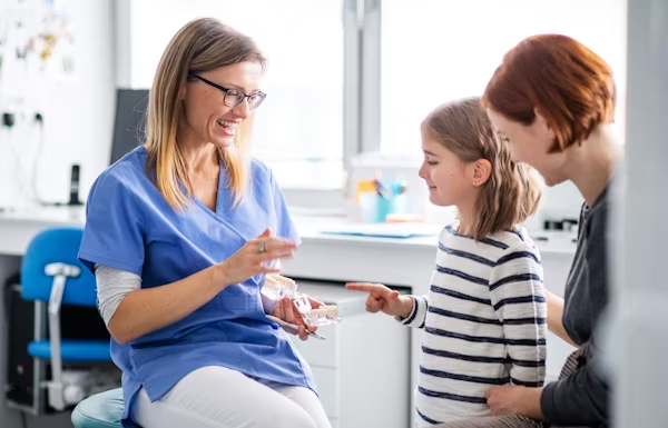a dentist talking to a kid while smiling