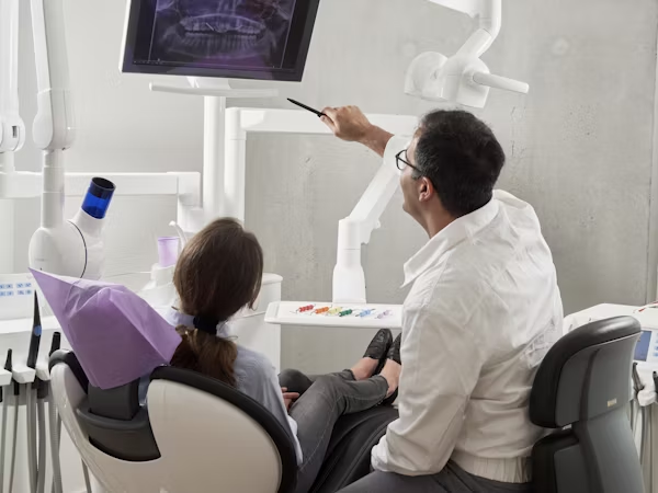 a dentist explaining a dental x-ray to his patient