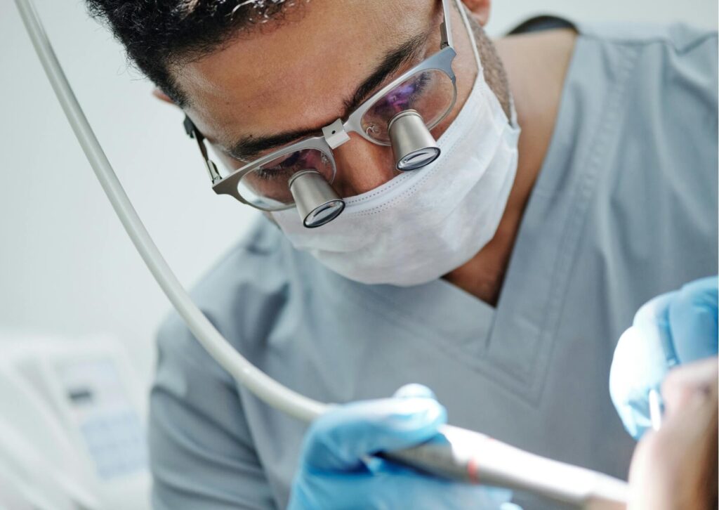 Dentist examining an adult patient's mouth during an evaluation for tongue-tie symptoms and oral function.